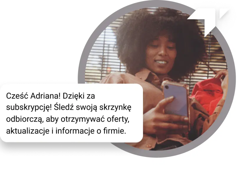 Dziewczyna z kręconymi włosami siedzi na podłodze, sprawdzając telefon, aby zobaczyć wiadomość „Dziękujemy” za subskrypcję.