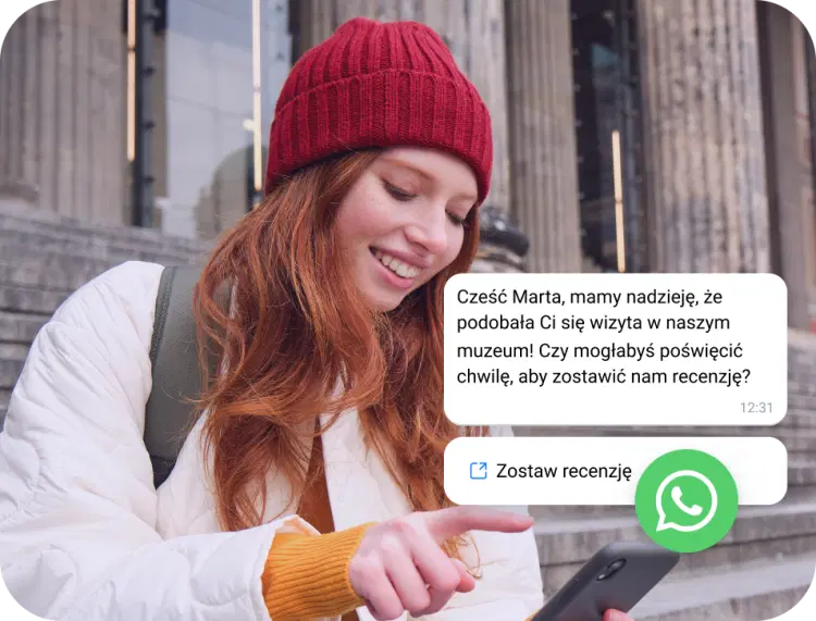 Dziewczyna w czerwonej czapce czytająca wiadomość biznesową WhatsApp na swoim telefonie