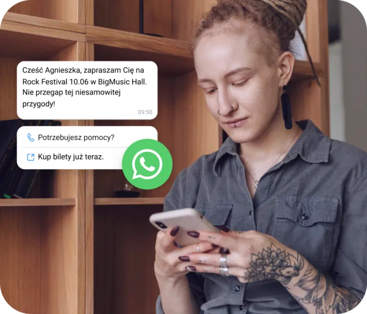 Dziewczyna z tatuażem sprawdza, czy w telefonie otrzymano zaproszenie na festiwal rockowy za pośrednictwem WhatsApp