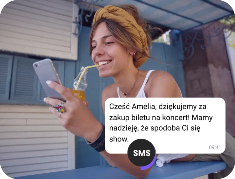 Dziewczyna pijąca sok na ulicy sprawdzająca potwierdzenie SMS-em o bilet na koncert