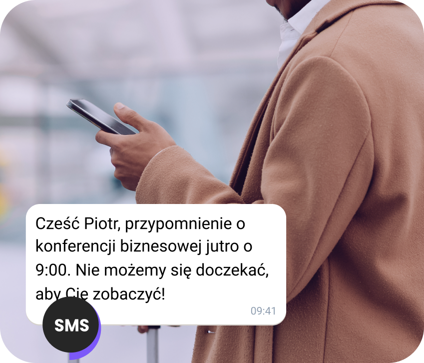 Mężczyzna na ulicy czyta przypomnienie o wizycie w SMS